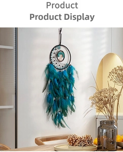 Detail of teal Tree of Life dreamcatcher with soft feathers and beads on white wall