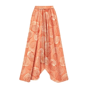 Detail of coral orange high-waisted wide-leg pants with white shell print and pleated texture