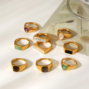Close-up of vintage gold stainless steel rings with colorful gemstones and shell inlays