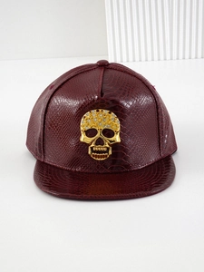 Detailed macro view of the maroon PU leather snake texture and studded skull ornament