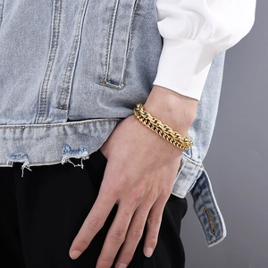 Detail of a chunky double-layered gold chain bracelet worn on a wrist for rock style