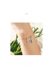 Detail of silver chain bracelet with hollow butterfly pendant and blue enamel butterfly