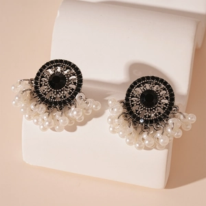 Detail of vintage bohemian earrings with white faux pearl tassels and rhinestones