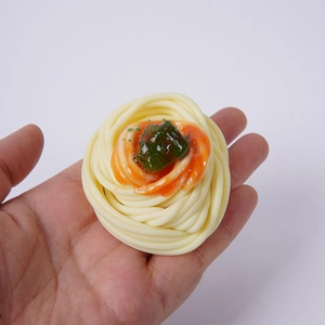 Modèle de pâtes spaghetti artificielles avec sauce tomate et garniture sur fond blanc