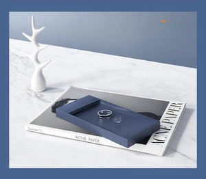 Detail view of a matte navy blue tray used for jewelry storage on an artistic magazine