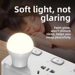 Mini spherical USB LED night light on power strip emitting soft warm yellow light