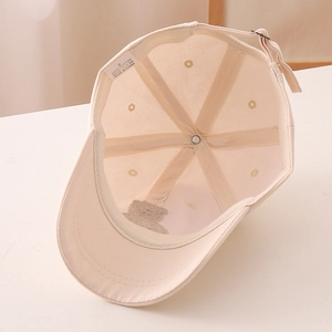 Detail of child's cotton baseball cap showing interior stitching and 100% cotton label