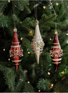 Detail of luxury spindle-shaped Christmas ornaments with beads and sequins on tree