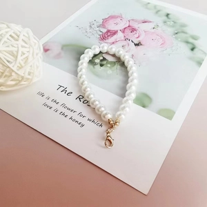Detail shot of white faux pearl chain with gold lobster clasp on floral card