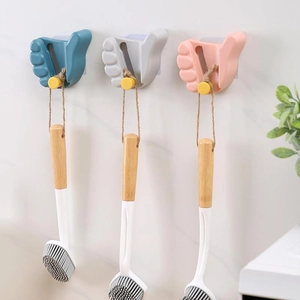 Three colorful palm-shaped mop holders on marble wall showing brush hanging utility