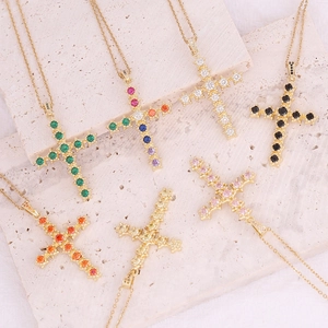 Detailed close-up of 18K gold cross pendants with multi-colored micro-pave zircons