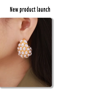 Close-up of elegant teardrop pearl cluster earrings in 18k gold finish on ear