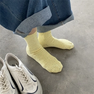 Detail of yellow ribbed cotton mid-calf socks with colorful donegal specks for summer
