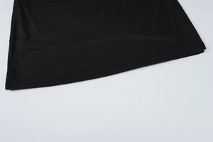 Detailed macro view of the double-stitched hem on the black slim-fit mini skirt set