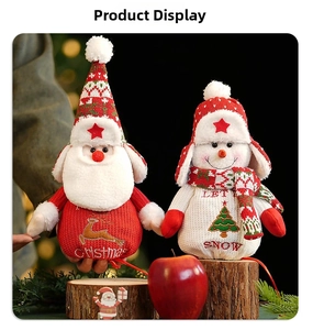 Plush Christmas Santa and Snowman gift bags displayed on a rustic wooden stump