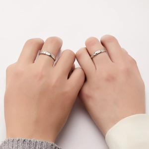 Close-up of couple rings featuring Love You and Forever engravings with small diamonds