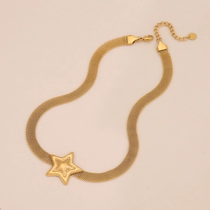 Flat lay macro of a gold heart mesh chain necklace with a large star pendant and lobster clasp