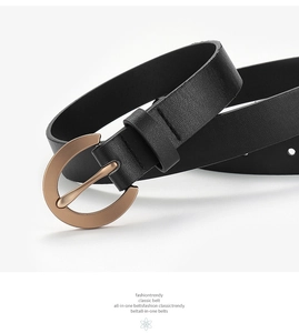 Detail of black pebbled leather belt with a golden semi-circle metal buckle