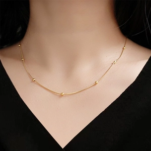Minimalist rose gold beaded snake chain necklace displayed on a female model neck