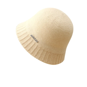 Minimalist beige crochet bucket hat with metallic 'FASHION' detail and ribbed texture