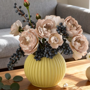 Vertical striped yellow ceramic vase with pink roses on a wooden table in home setting