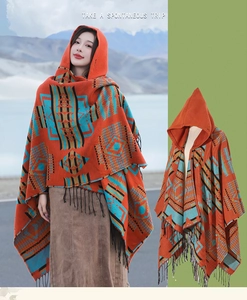 Close-up of ethnic orange hooded poncho featuring geometric patterns and black tassels