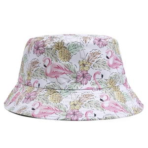 Close-up of reversible bucket hat featuring tropical flamingo and pineapple prints
