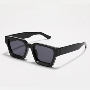 Close-up detail of stylish thick black square frame sunglasses with dark lenses for adults