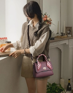 Detail of wine red lychee pattern handbag with silk scarf handle and metal lock