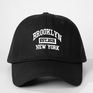 Detail of white Brooklyn New York 3D embroidery on black cotton baseball cap fabric