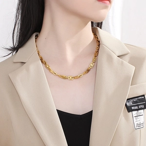 Goldene Halskette mit Schweinenasen-Gliedern, getragen am Model mit beigem Blazer