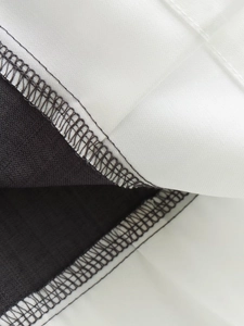 Close-up of high-quality stitching and dual-needle seams on black and white fabric