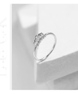 Macro detail of silver crown ring featuring rectangular zircons on geometric stand
