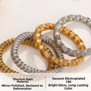 Macro detail of 18K gold and silver plated titanium steel twisted cable bracelets