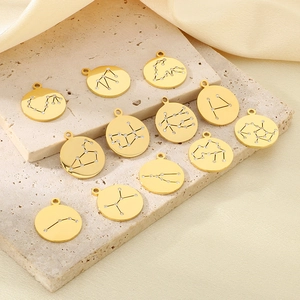 Detailed view of 18K gold plated zodiac pendants with crystals on a stone surface