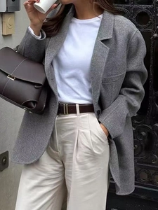 Street style detail of a grey wool blazer paired with wide-leg trousers and handbag