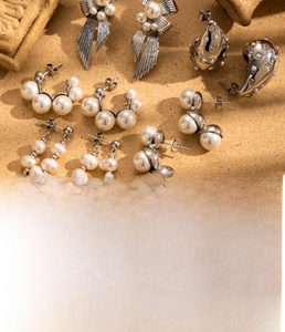 Detailed view of titanium steel earrings with pearls and zircon in a luxury setting