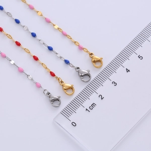 Close-up of titanium steel choker with colorful enamel lip beads and lobster clasp