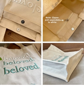 Detail view of embroidered beloved lettering, magnetic snap and inner zipper pocket