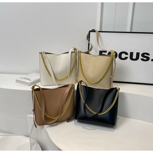 Detailed view of large capacity tote bags in black white brown and beige with gold chains