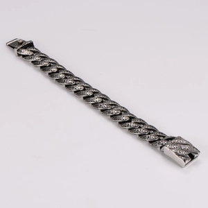 Gros plan détaillé du bracelet en acier inoxydable ciselé avec textures noires rétro