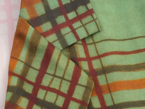 Dettaglio del rever e della fantasia scozzese colorata su un blazer sartoriale sfiancato