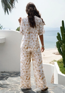 Rear view of woman in summer set with beach prints on a tropical seaside background