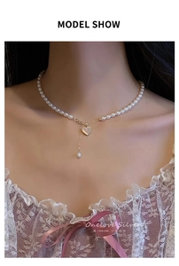 Close-up of elegant freshwater pearl necklace with heart pendant on female model