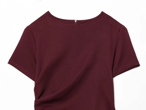 Detail of burgundy short-sleeve dress featuring a side drape pleat and back zipper closure