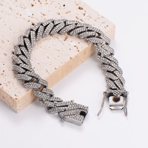 Silver iced-out Cuban link chain necklace with sparkling crystals on a stone base