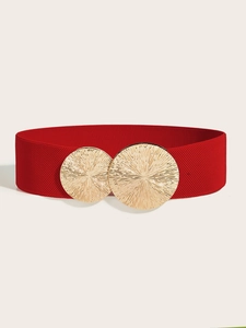 Close-up of a red elastic wide belt featuring a textured golden circular buckle for dresses