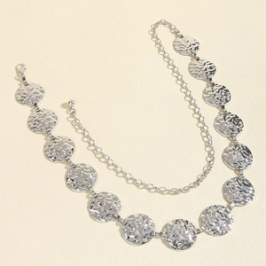 Macro detail of silver circle waist chain with hammered texture and adjustable clasp