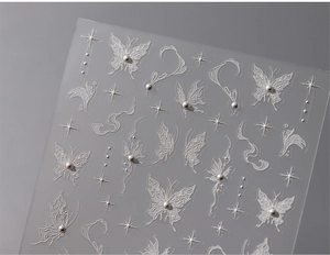 Macro shot of 3D embossed snowflake and butterfly nail stickers with pearl textures