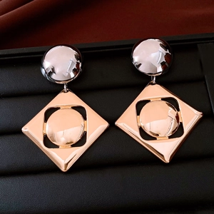 Detailed view of silver and rose gold geometric earrings with a polished metallic finish
